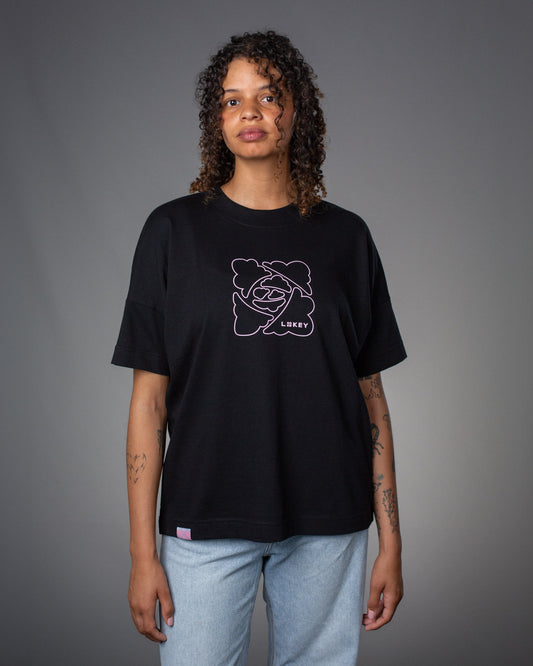 Vorderansicht eines schwarzen T-Shirts mit rosa Liniengrafik auf der Brust. Das Design zeigt eine fröhliche Wolkenfigur mit Sonnenbrille und Hut, ergänzt durch den Schriftzug „LOKEY“.